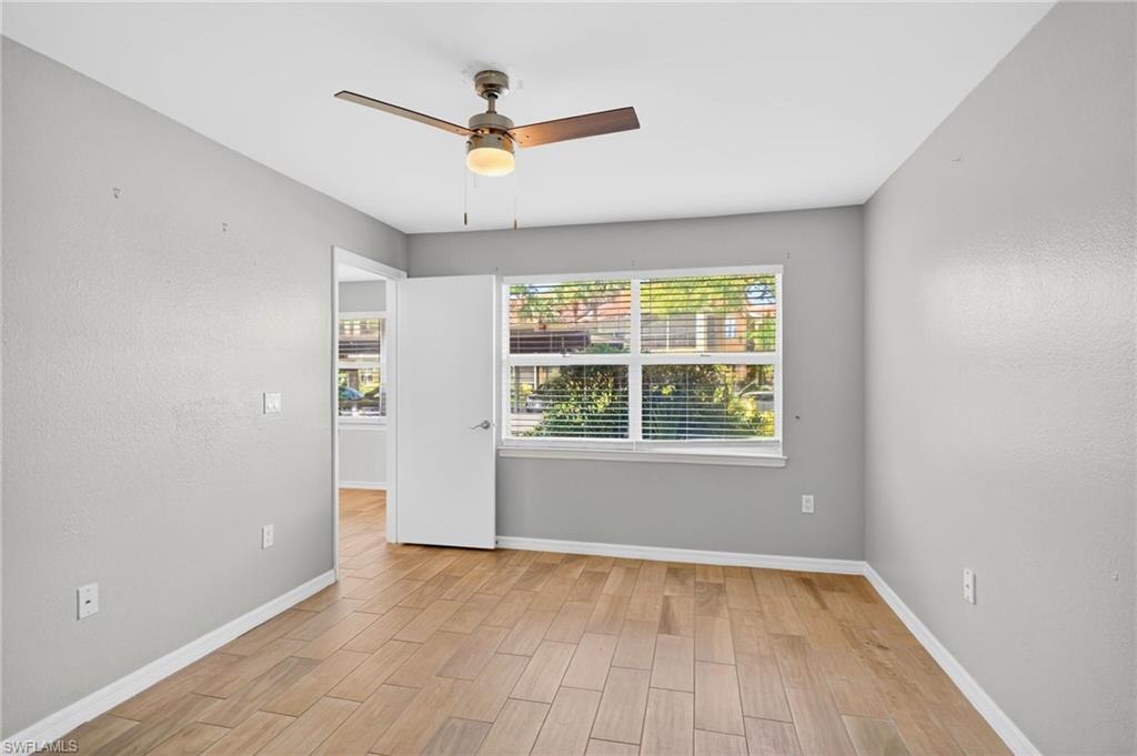 Unfurnished room featuring wood finish floors, healthy amount of natural light, and ceiling fan