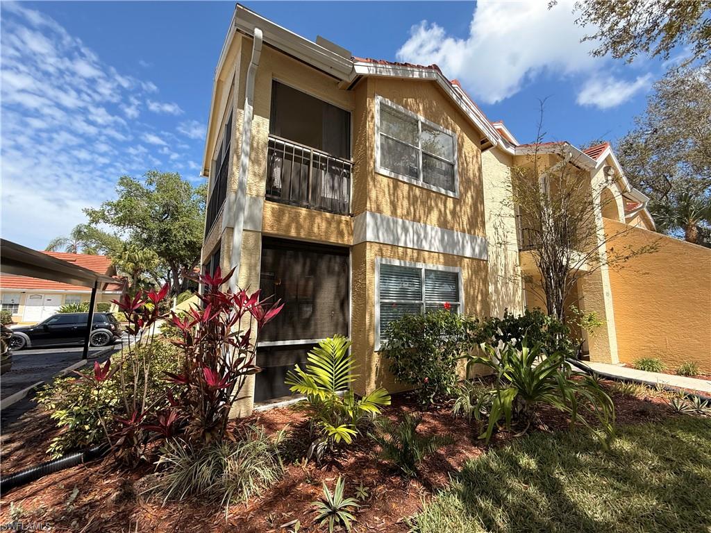 View of front of home with a sunroom and a balcony