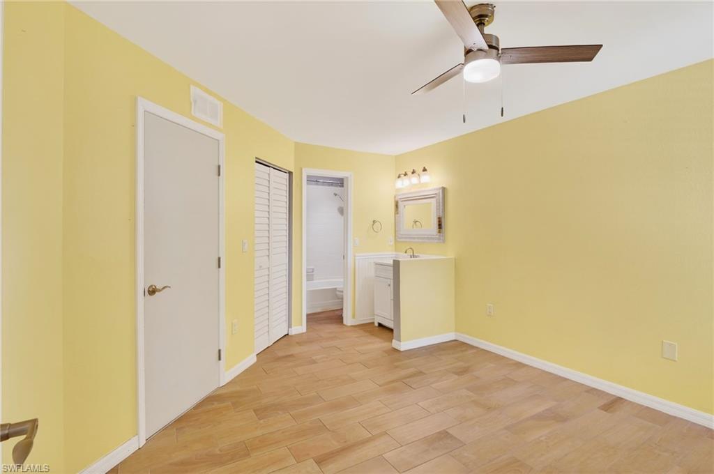 Unfurnished bedroom with ceiling fan, light wood-style floors, a closet, and connected bathroom