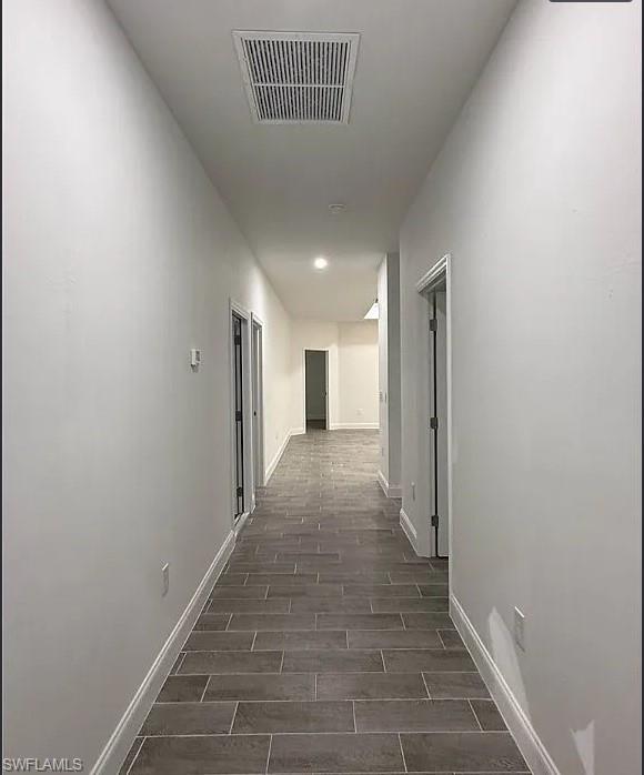 Hall featuring baseboards and wood finish floors