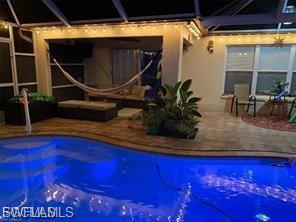 Swimming pool with a patio area, a sunroom, and glass enclosure