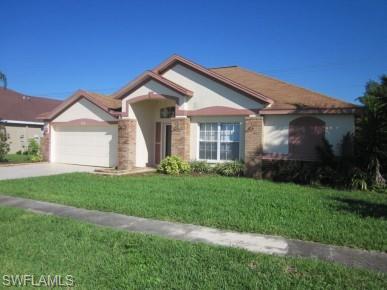 Single story home with a front lawn, a garage, concrete driveway, and stucco siding