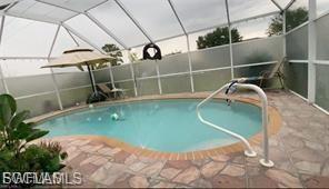 View of swimming pool with a lanai, a fenced backyard, and a sunroom