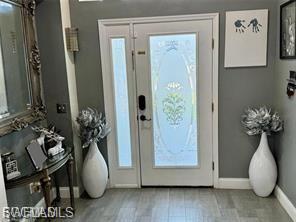 Entryway with baseboards and light wood-style flooring