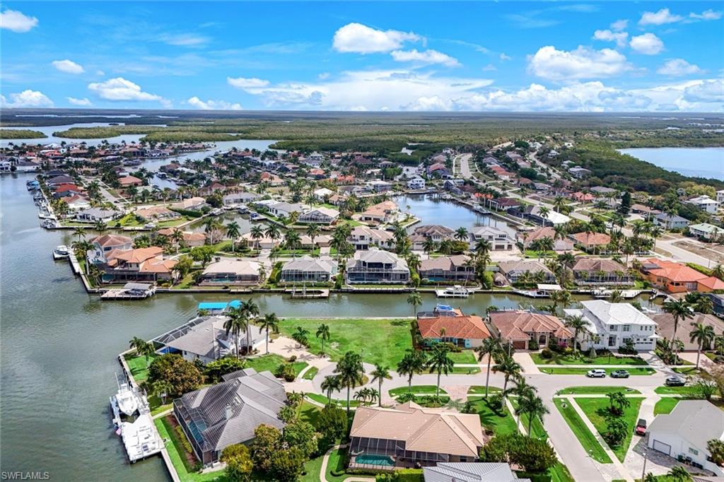 Aerial perspective of suburban area featuring a nearby body of water