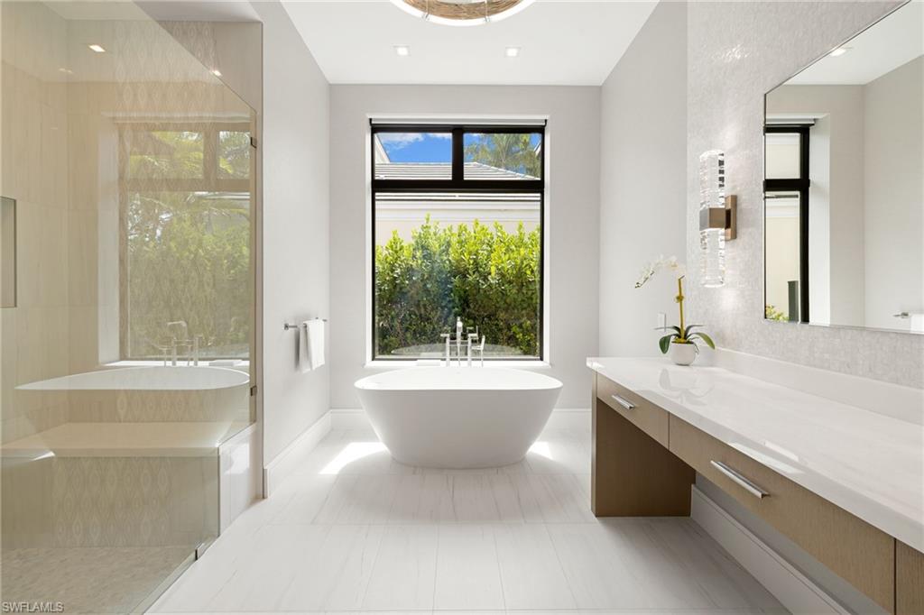 Bathroom featuring a soaking tub, vanity, walk in shower, and recessed lighting