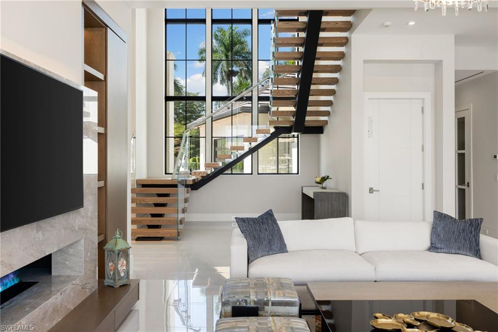 Living area featuring a high end fireplace and stairs