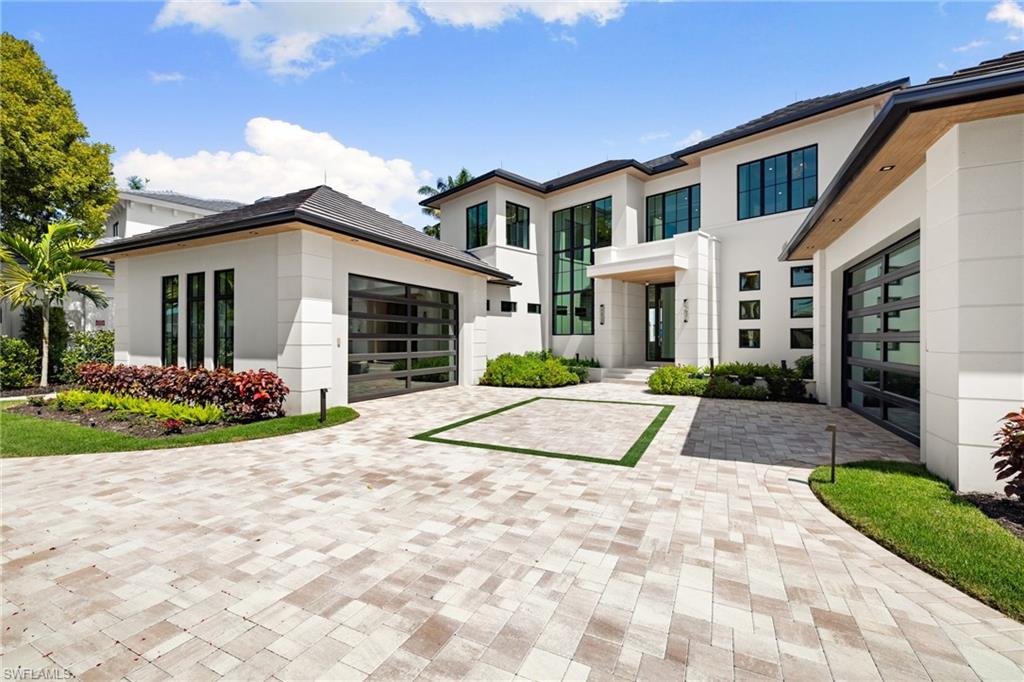 Modern home with stucco siding, decorative driveway, and an attached garage