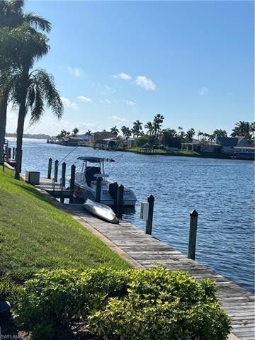 Dock area with a water view and a lawn