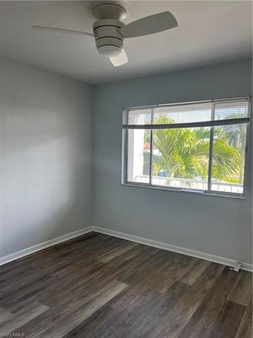 Unfurnished room with dark wood finished floors and a ceiling fan