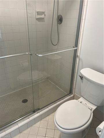 Full bath with a stall shower and light tile patterned floors
