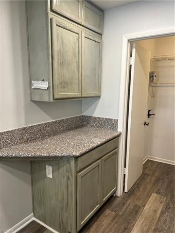 Bathroom with dark wood finished floors, vanity, and a spacious closet