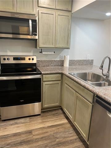 Kitchen with stainless steel range, dishwashing machine, dark wood finished floors, and dark stone counters