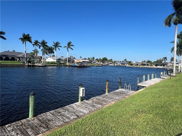 Dock featuring a lawn, a water view, and a residential view