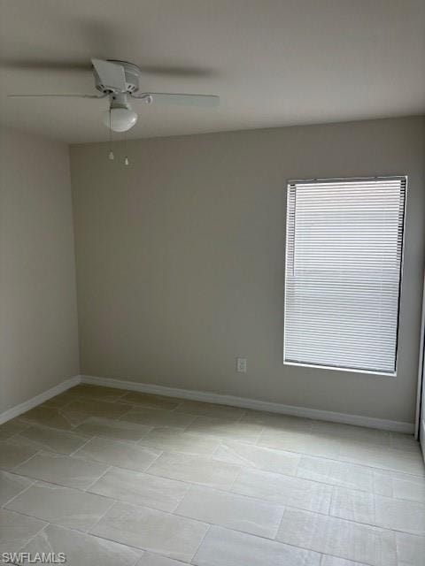 Spare room with a ceiling fan and baseboards