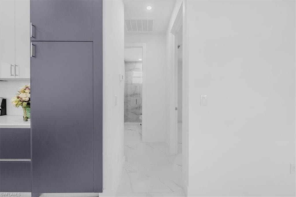 Hall with recessed lighting and light marble finish flooring