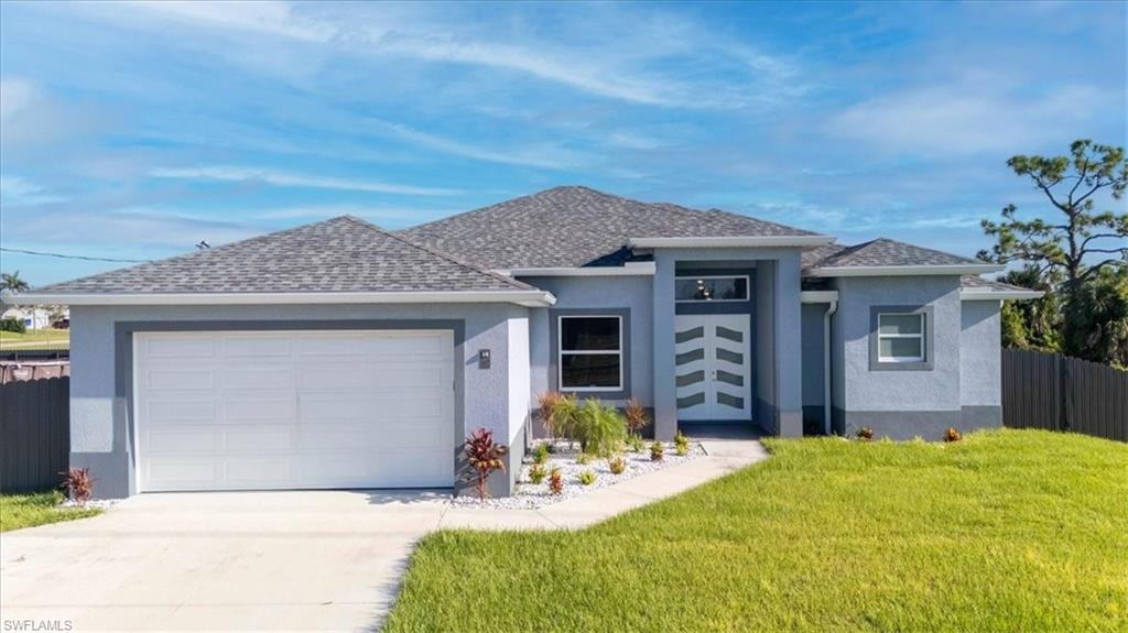 Prairie-style home featuring a garage, stucco siding, driveway, and a shingled roof