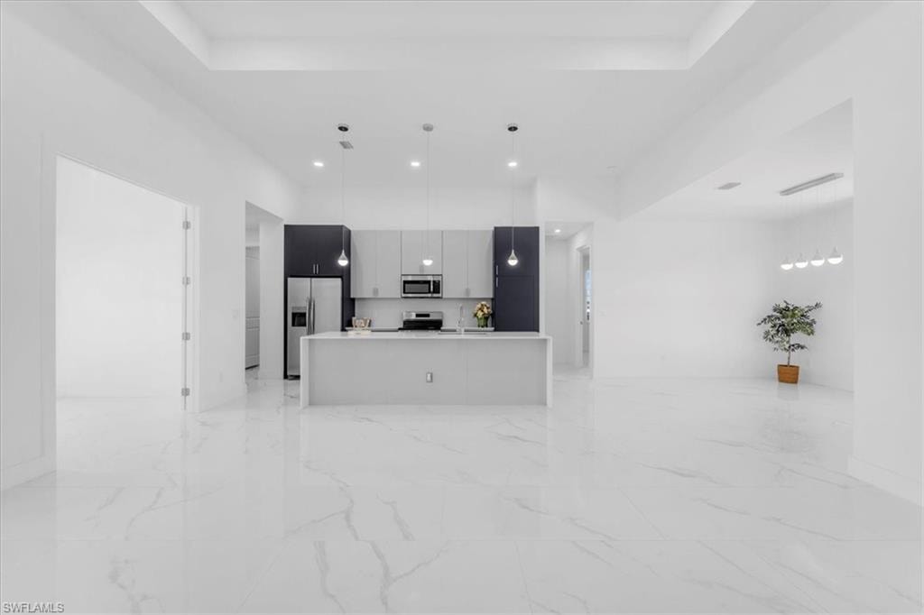 Unfurnished living room featuring a tray ceiling and recessed lighting