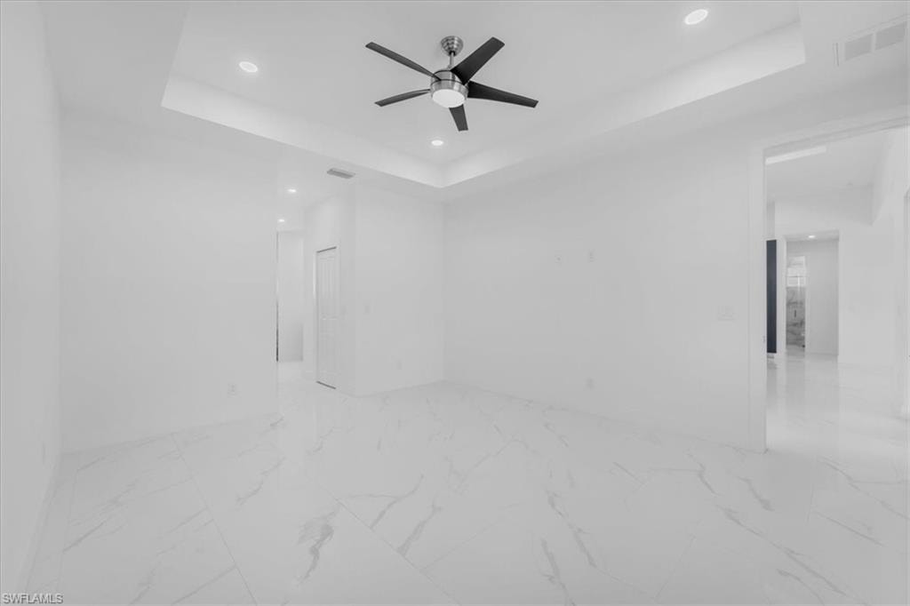 Detailed view of a raised ceiling, recessed lighting, and ceiling fan
