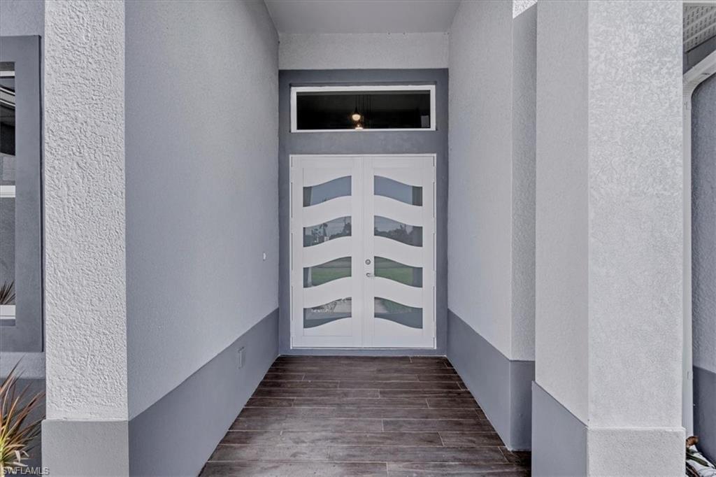 View of exterior entry with stucco siding and french doors