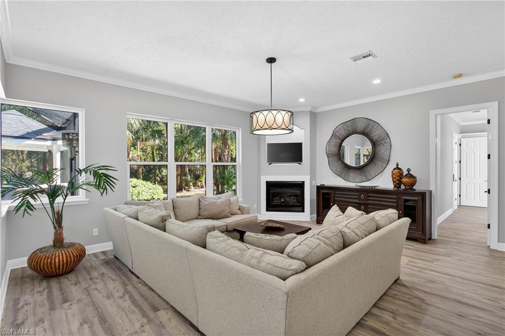 Great room off the kitchen  with fireplace and sliders out to the lanai via kitchen.