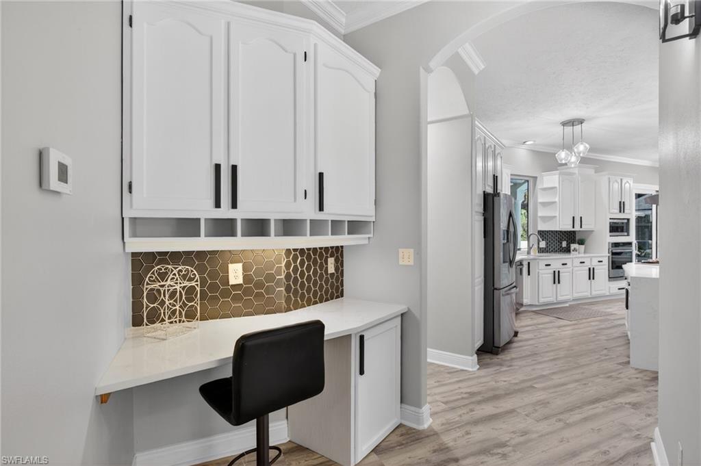 Desk with matching backsplash/cabinetry in an alcove off of the kitchen.