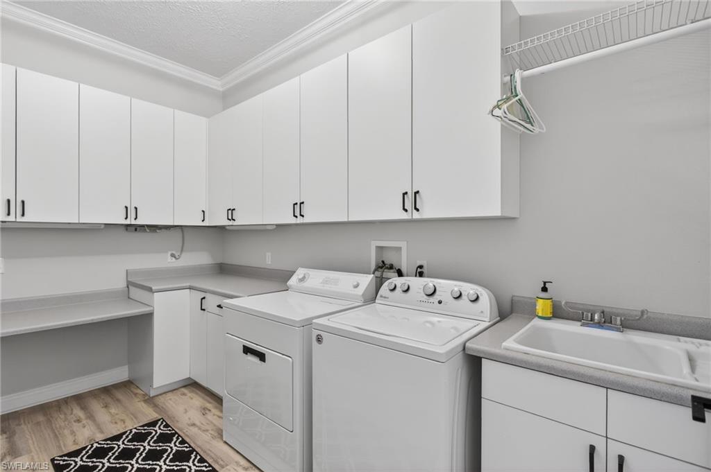 Spacious laundry with tons of storage, laundry sink, and folding area.