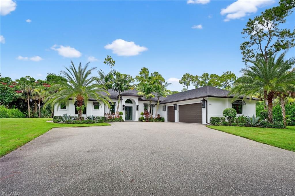 Single story home with an attached garage, a front yard, asphalt driveway, and stucco siding