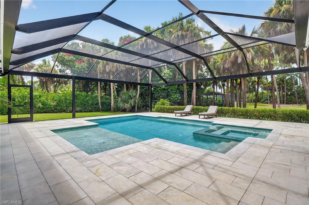 Integrated pool / hot tub featuring a patio area, glass enclosure, and a sunroom