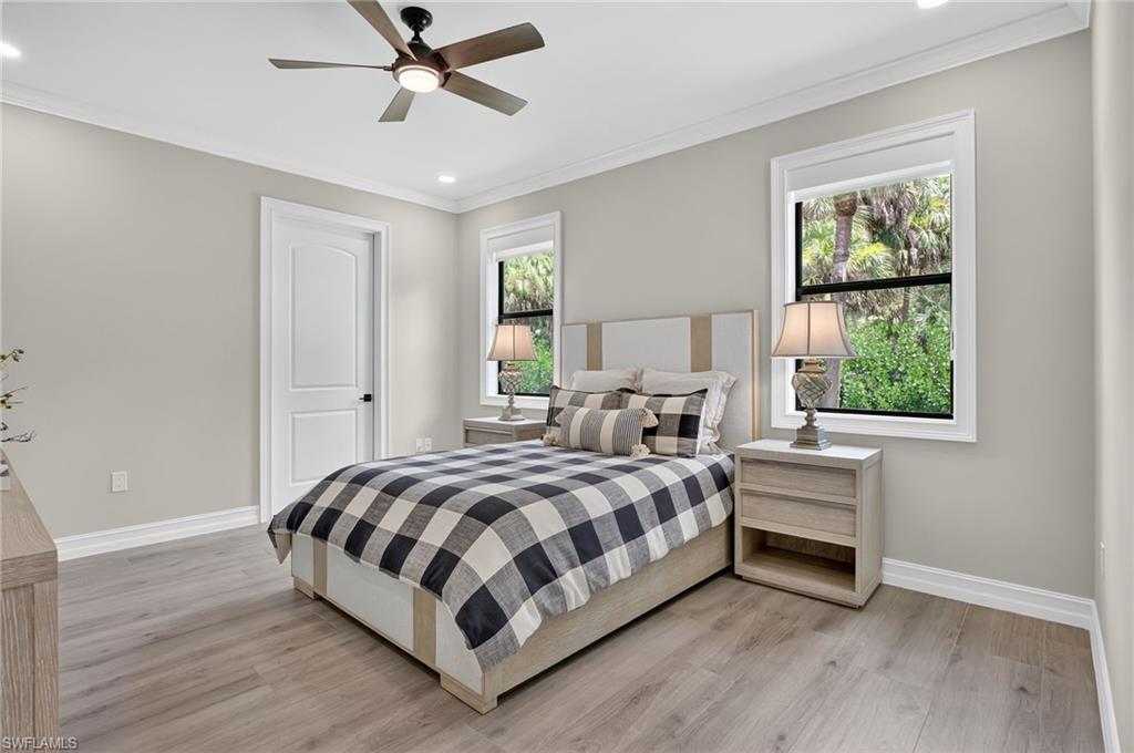 Bedroom with light wood-style floors, ornamental molding, a ceiling fan, and recessed lighting