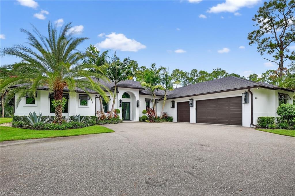 Single story home with an attached garage, driveway, stucco siding, and a shingled roof
