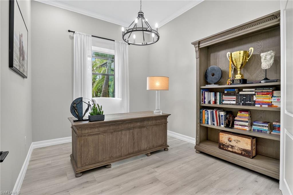 Office with crown molding, suspended lighting, and light wood-type flooring