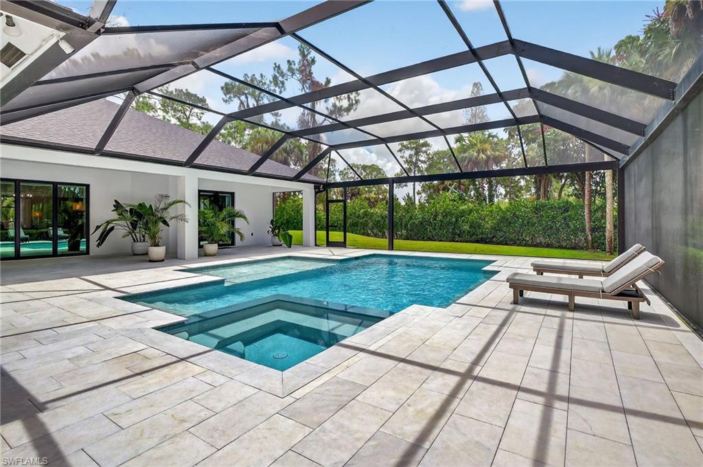 Integrated pool / spa with a sunroom, a patio, and a lanai