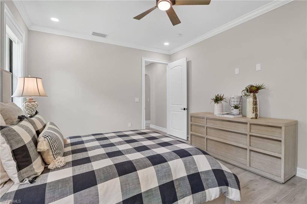 Bedroom featuring ornamental molding, a ceiling fan, recessed lighting, arched walkways, and light wood finished floors