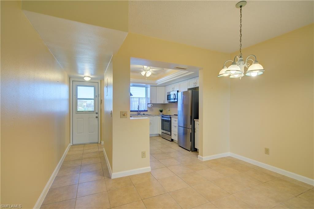 Dining Room area with suspended lighting and a raised ceiling.