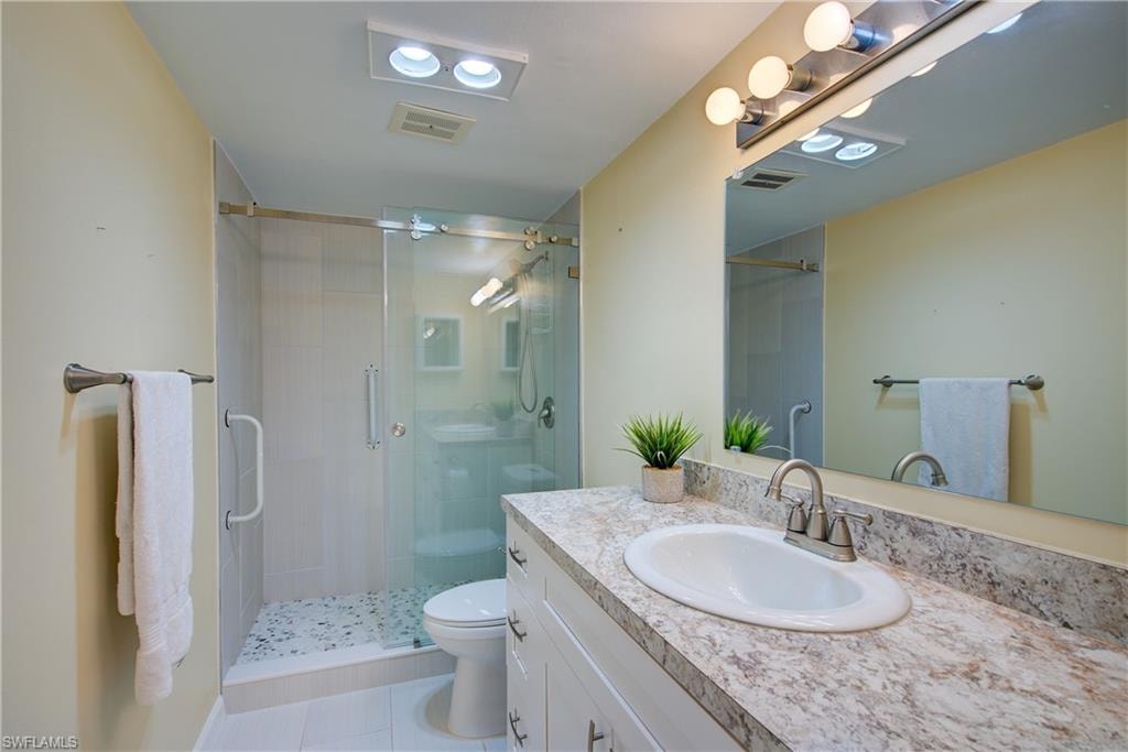 Bathroom with vanity, a stall shower, and light tile patterned floors