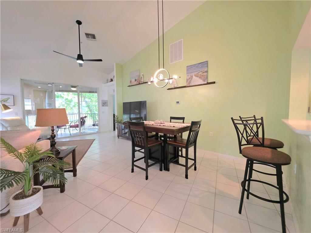 Dining room featuring lofted ceiling, light tile patterned floors, and a ceiling fan