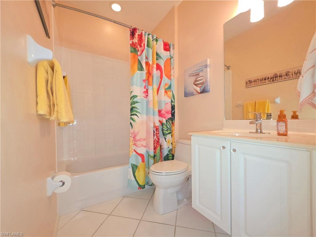 Full bath featuring vanity, light tile patterned floors, shower / bath combination with curtain, and recessed lighting