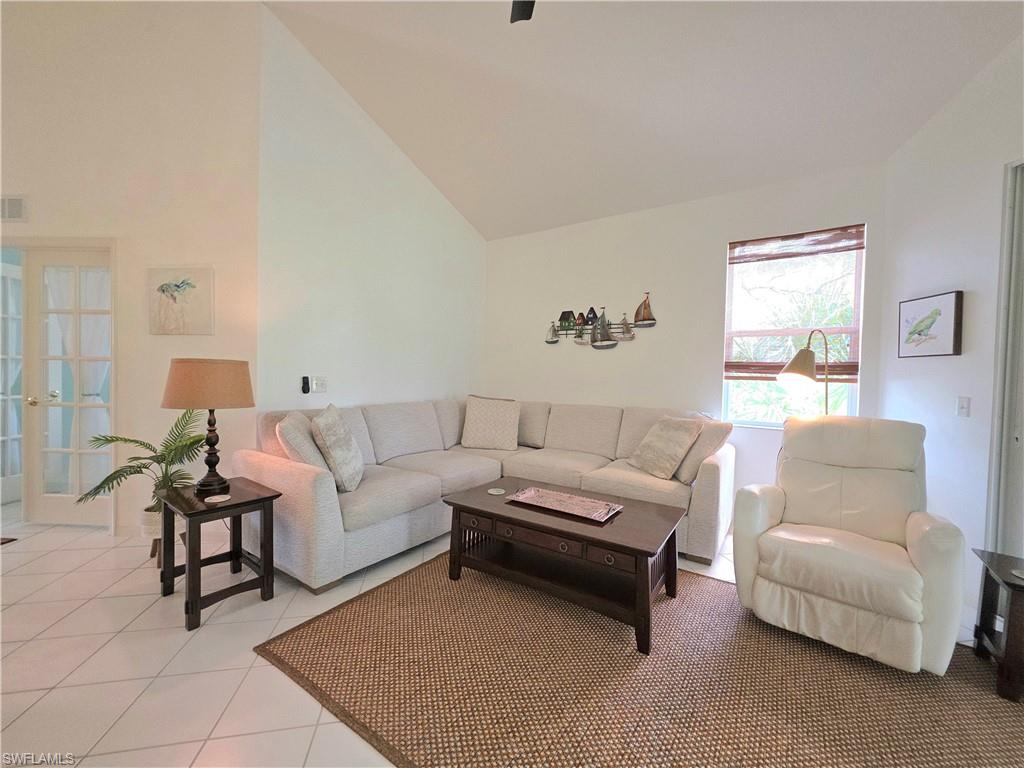 Tiled living area with vaulted ceiling and french doors