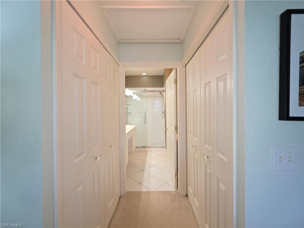 Hall with light tile patterned floors and light carpet
