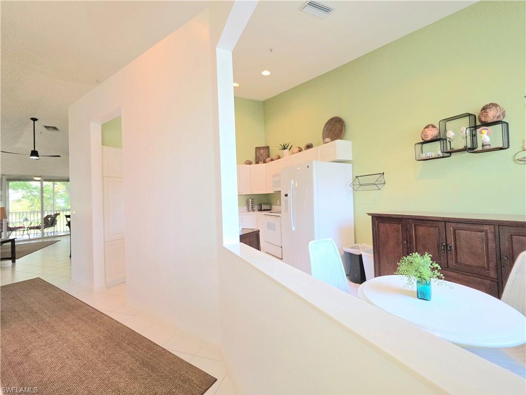 Hall with light tile patterned floors and recessed lighting
