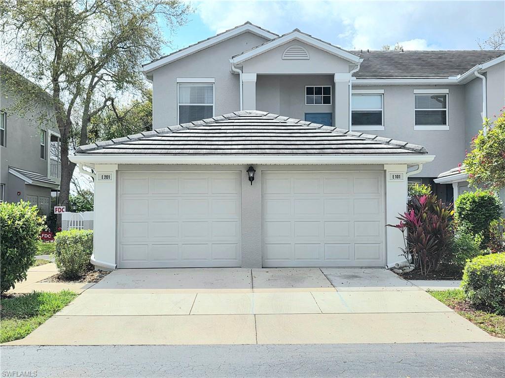 Traditional-style home with concrete driveway, an attached garage, stucco siding, and a tiled roof