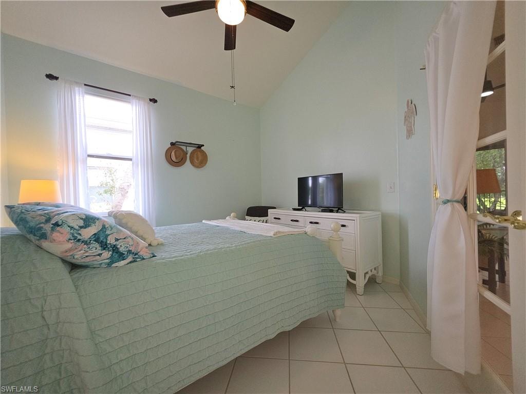 Bedroom featuring lofted ceiling, a ceiling fan, and light tile patterned floors