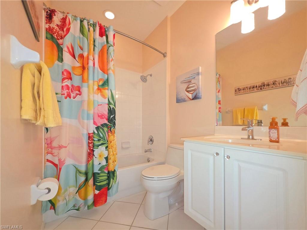 Full bath featuring vanity, light tile patterned floors, shower / bath combination with curtain, and recessed lighting