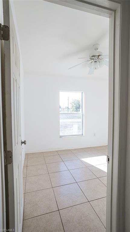 Empty room with light tile patterned flooring and ceiling fan