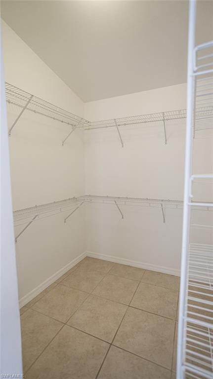 Walk in closet with light tile patterned floors