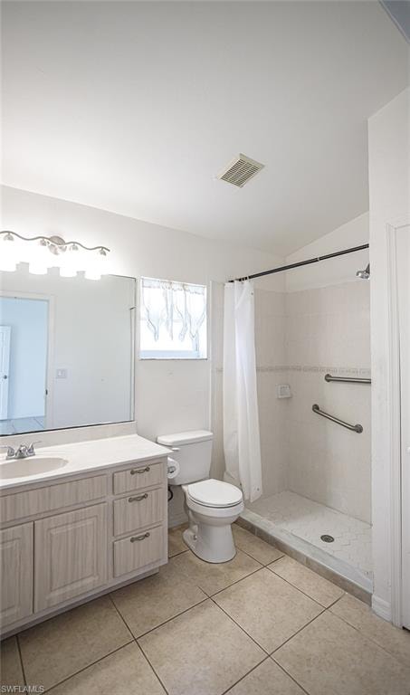 Bathroom with vanity, a shower stall, light tile patterned floors.