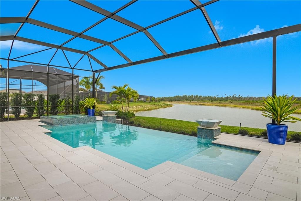 Integrated pool / hot tub featuring a lanai, a sunroom, a lawn, a water view, and a patio