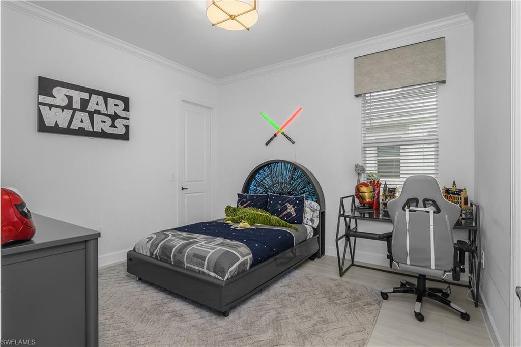 Bedroom featuring crown molding and light wood-style floors