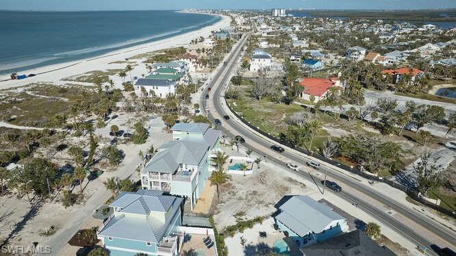 Birds eye view of property with a water view and a view of the beach